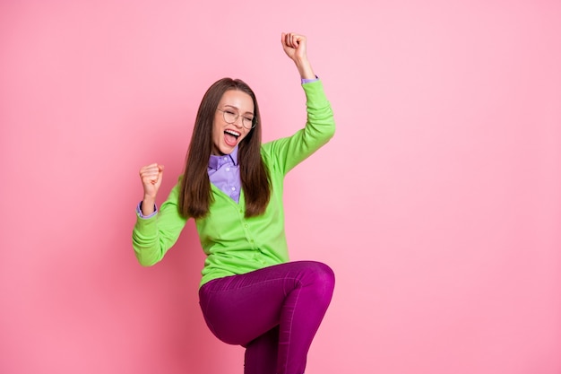 Portrait of delighted girl lucky lottery win raise fists scream isolated over pink color background