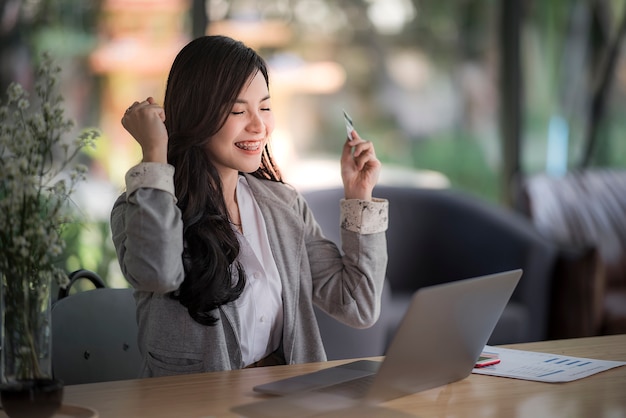 Portrait of a delighted young woman holding credit card