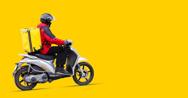 Portrait of delivery man in uniform holding parcel box isolated over yellow background.