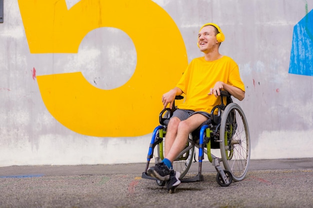 Portrait of a disabled person dressed in yellow in a wheelchair listening to music