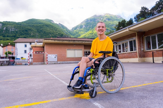 Portrait of a disabled person dressed in yellow in a wheelchair in the schoolyard