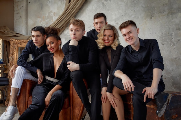 Portrait of diverse group of young people musical band playing with instruments on gray concrete background