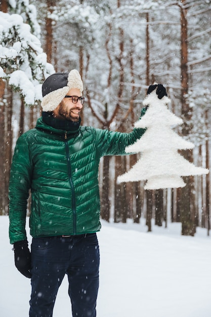 Portrait of dlightful positive bearded male dressed in warm winter clothes