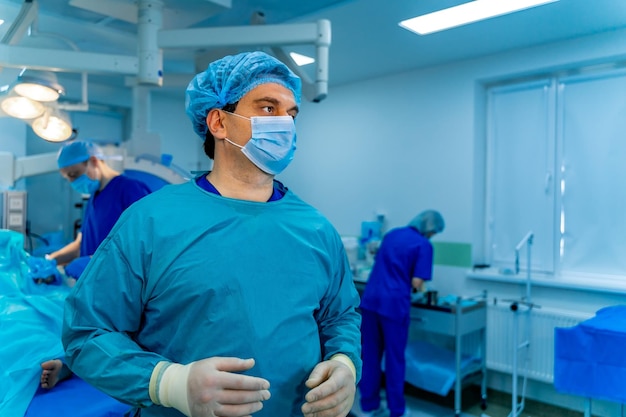 Portrait of a doctor or medical specialist Horizontal portrait Man in scrubs Operating room background with blue light Closeup