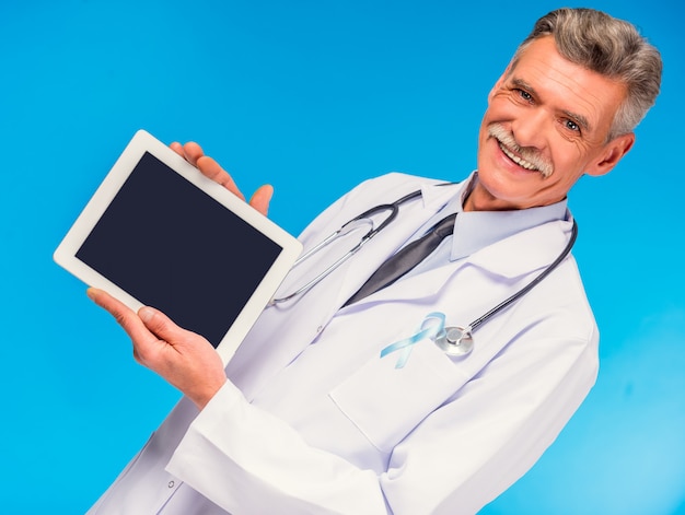 Portrait of doctor with blue ribbon holding the tablet.