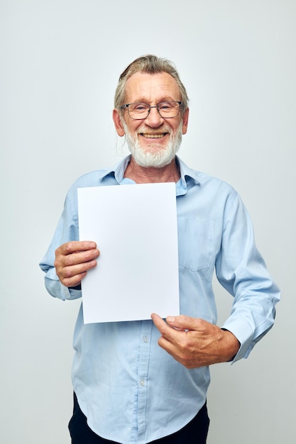 Portrait elderly man holding a sheet of paper copyspace posing cropped view