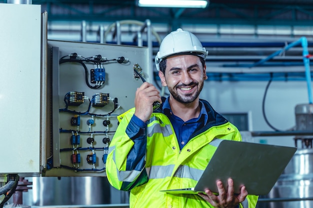 Portrait electricity worker hispanic engineer working in factory checking high voltage electrical power cabinet in factory