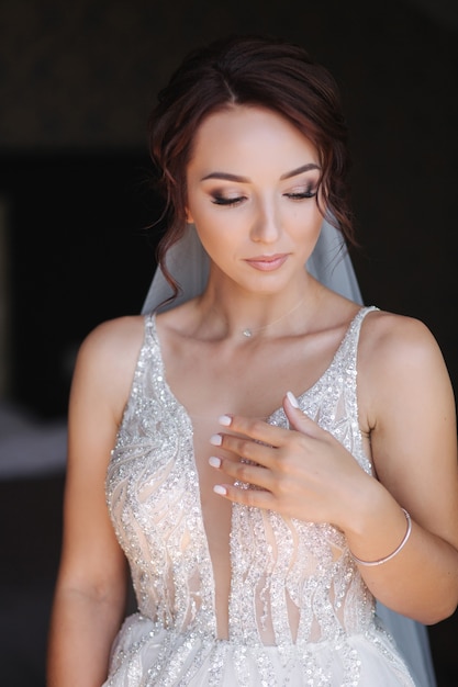 Portrait of elegant bride in fashion wedding dress stand on the balcony and posing