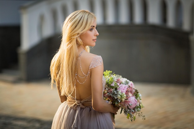 Portrait of an elegant pretty woman wearing grey wedding dress and posing