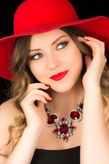 Portrait of elegant woman with red hat and luxury necklace