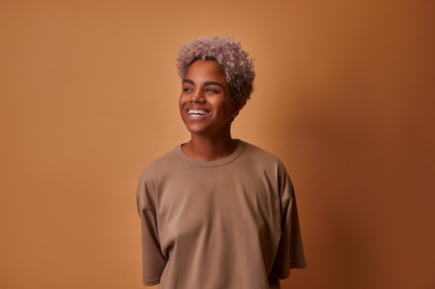 Portrait of emotional beautiful african american woman laughing looking to the side and standing aga...