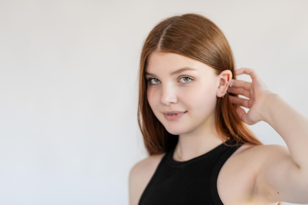 Portrait of an emotional redhaired girl with freckles and braces on a white background