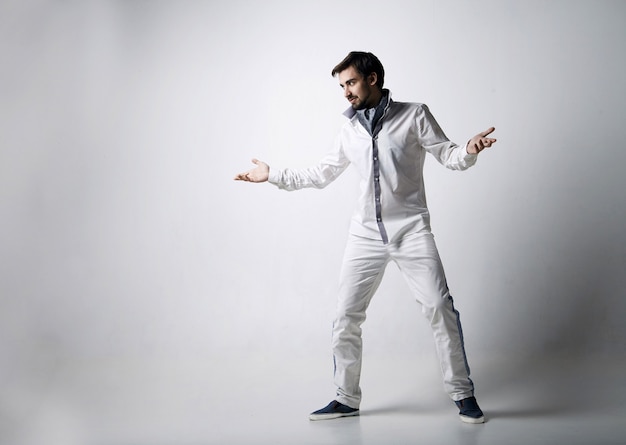 Portrait of an emotional young man wearing white. Isolated over white background.