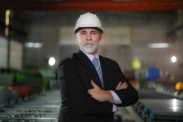 Portrait engineer Senior boss standing confident in industry factory Concept of smart industry operation and maintenance older engineer with beard mustache on face standing