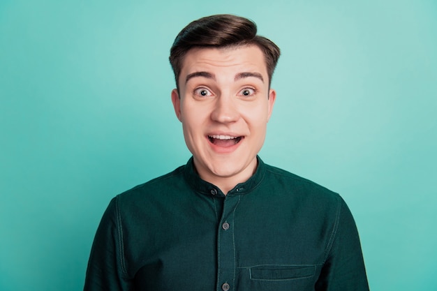 Portrait of excited crazy guy palm ear eavesdropping close look camera omg reaction on turquoise background