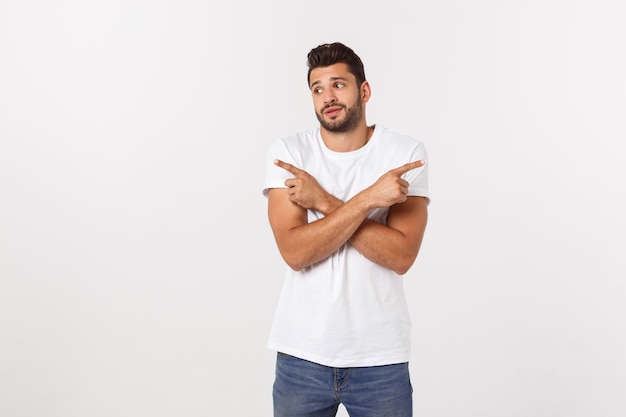 Portrait of an excited happy man pointing finger away at copy space. Isolated on yellow.