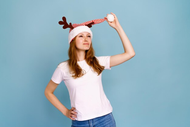 Photo portrait of an excited smiling caucasian girl dressed as christmas deer and white tshirt smiling che...