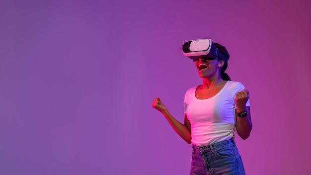 Portrait Of Excited Young Black Woman In VR Glasses Celebrating Success