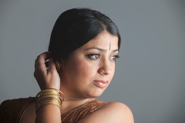 Portrait of an exotic brunette indian woman with dark skin. brown eyes and a bindi on her face.