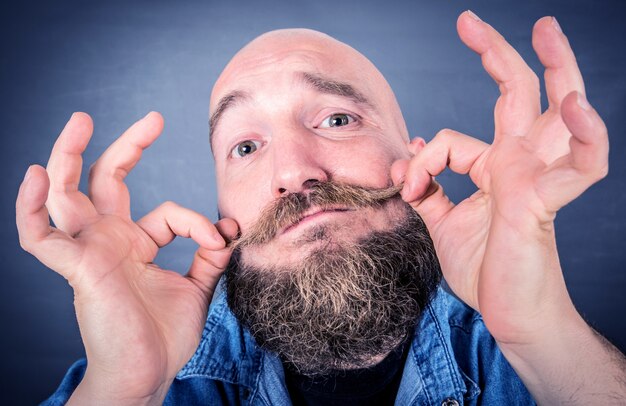 Portrait of expressive bearded man isolated on grey