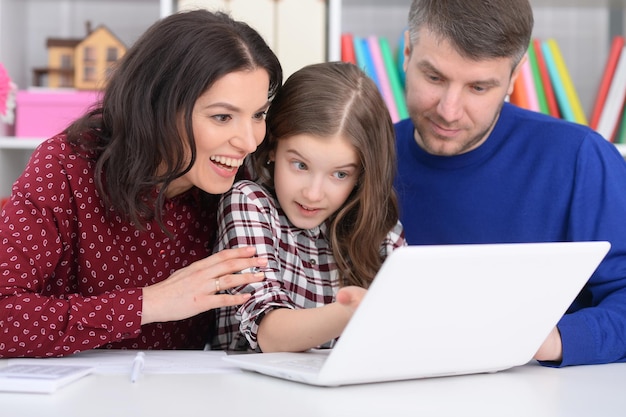 Photo portrait of a family with a daughter using a laptop