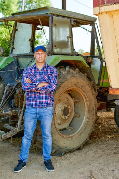 Portrait of farmer by tractor in countryside.