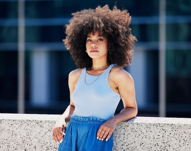 Portrait fashion and attitude with a black woman in the city outdoor on a bridge during a summer day Street style or urban and an attractive young female posing outside with an afro hairstyle