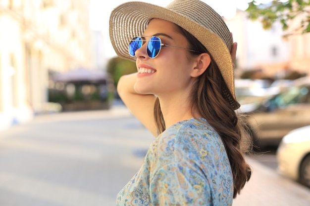 Portrait fashion woman is posing in the city, summer street fashion. Laughing and smiling portrait.