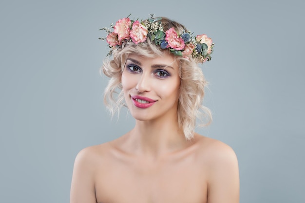 Portrait of fashion woman with flowers Cheerful model with short hair and makeup smiling