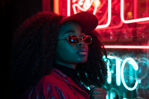 Portrait of fashion young girl in sunglasses in red and blue neon light in the studio