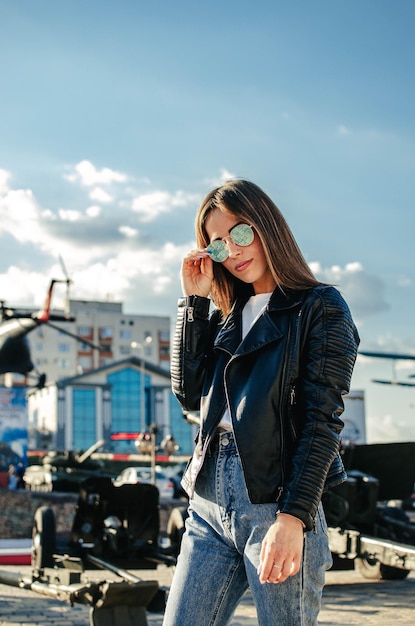 Portrait of a fashionable girl with sunglasses on the street in bright sunlight