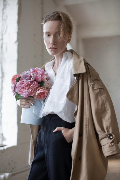 Photo portrait of fashionable woman with bouquet at home