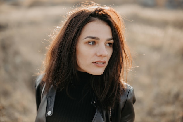 Portrait of a fashionable young brunette woman in a leather jacket