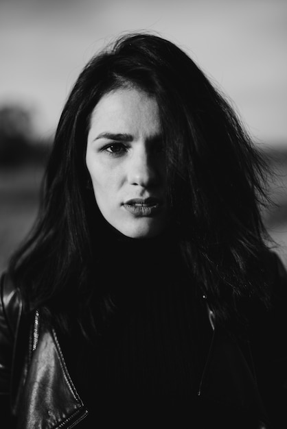 Portrait of a fashionable young Caucasian brunette girl in a leather jacket