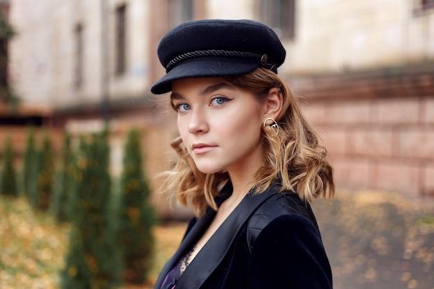 Portrait of fashionable young girl posing on street