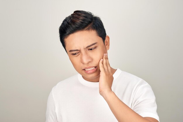 Portrait of fat Asian man use his hand touch his cheek feeling painful from toothache Oral health concept