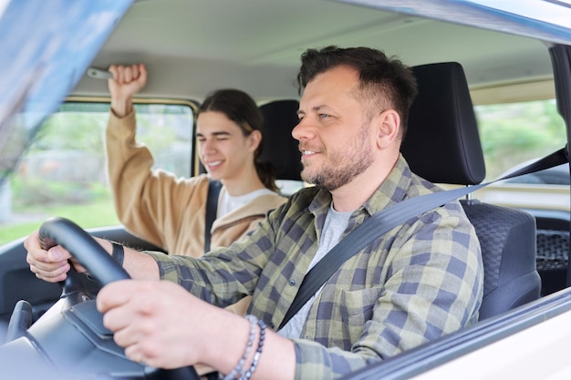 Portrait of father and teenage son together man driving car