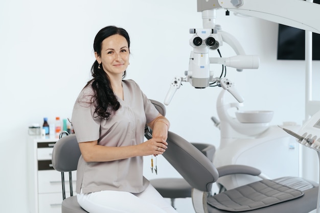 Portrait of female dentist smiling with arms crossed in dental clinic