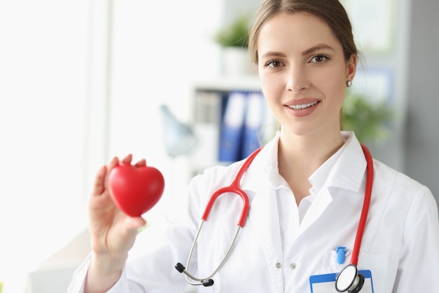 Portrait of female doctor cardiologist with small heart in her hand