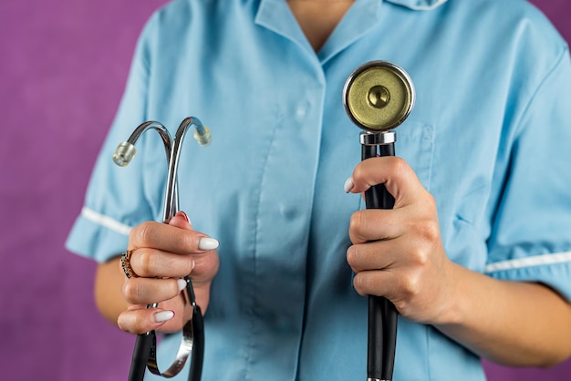 Portrait of female doctor in uniform with stethoscope isolated on plain background