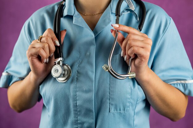 Portrait of female doctor in uniform with stethoscope isolated on plain background