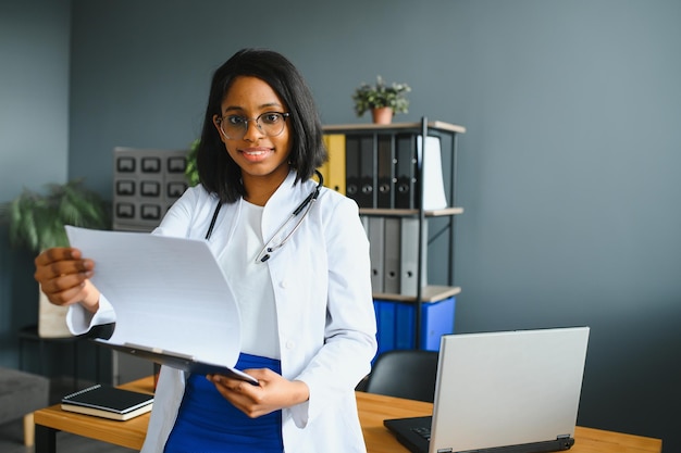 Portrait Of Female Doctor Wearing White Coat In Office