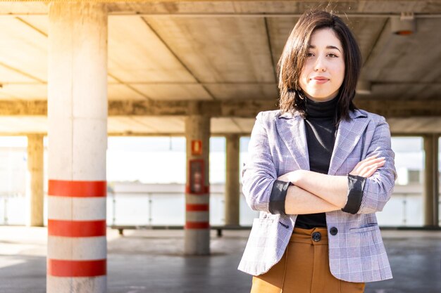 Portrait of female entrepreneur in formal suit with crossed arms outdoors Young woman in formal wear arms crossed outdoors