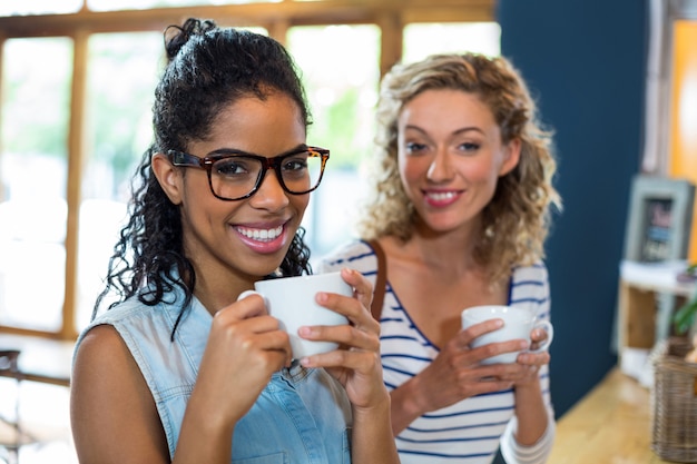 Portrait of female friends smiling while having coffee