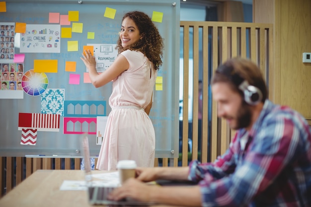 Portrait of female graphic designer standing near whiteboard