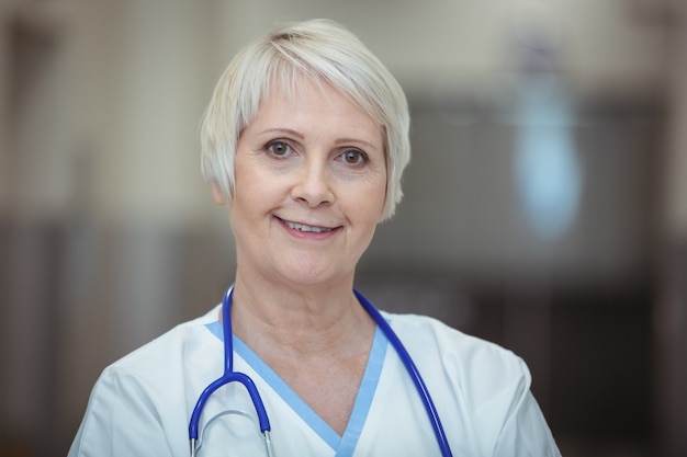 Portrait of female nurse standing in corridor