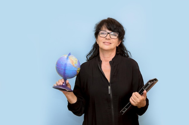 Portrait of female teacher with globe and laptop and inspired expression