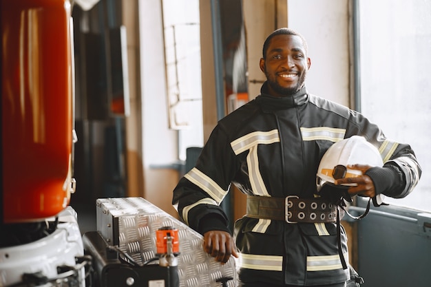 Portrait of a firefighter standing in front of a fire engine