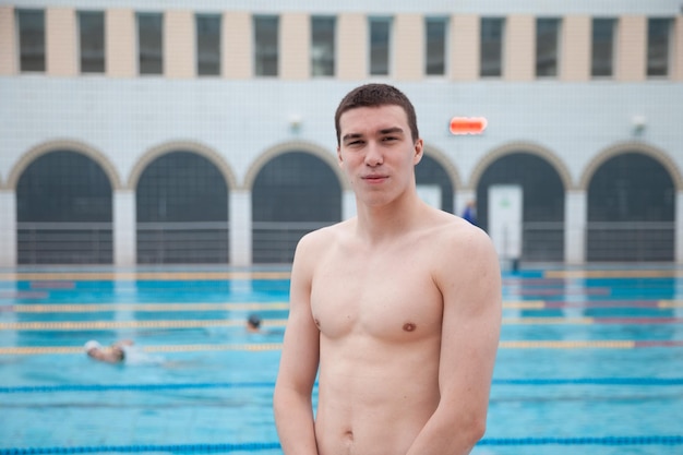 Portrait of a fit swimmer man at pool looking at camera Portrait of competitive male swimmer near swimming pool