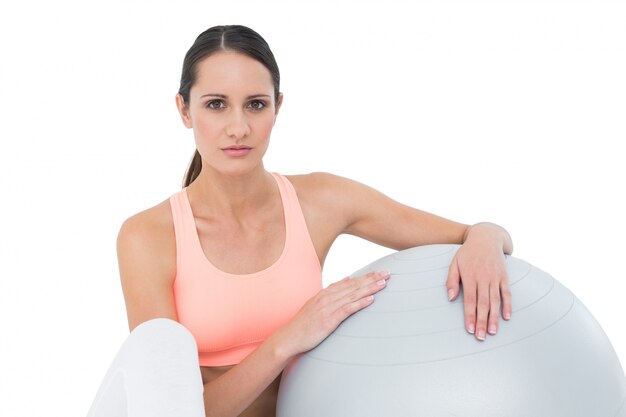 Portrait of a fit woman sitting with fitness ball